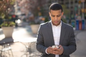 Young African American black Latino man texting cellphone